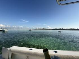A picturesque scene featuring a group enjoying the clear waters at a beach, with boats anchored nearby — perfect for a day of fun in the sun.