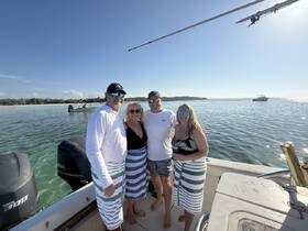 A cheerful group of friends poses together on a boat, enjoying a sunny day on the water — perfect for memorable outings and celebrations.