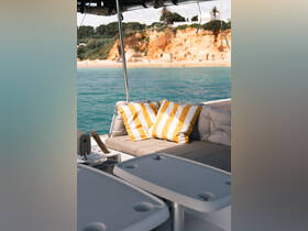 A cozy seating area on a boat featuring stylish striped cushions, perfect for relaxing while enjoying the scenic views of the coastline.
