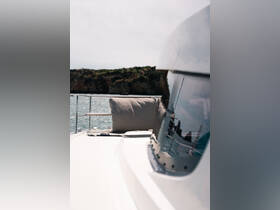 A serene view of a yacht's side with a comfortable cushion, showcasing the tranquil waters and rocky coastline in the background — perfect for relaxation on the open sea.