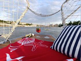 A beautifully arranged setting on a boat featuring cocktails, strawberries, and snacks, perfect for a relaxing day on the water.