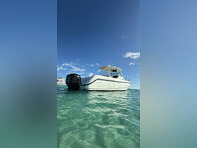 A sleek speedboat glides through clear turquoise waters, showcasing its elegant design against a bright blue sky.