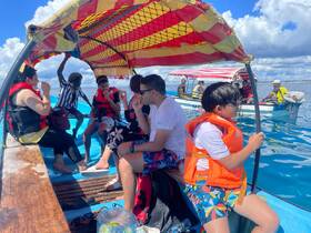 A lively group enjoys a boat ride, wearing life jackets and sharing snacks, capturing the essence of family fun on the water.
