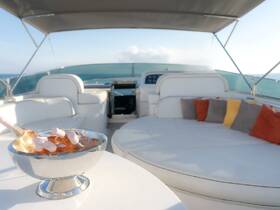 A stylish interior view of a boat's lounge area featuring comfortable seating and a chilled bowl of rosé, perfect for relaxing on the water.