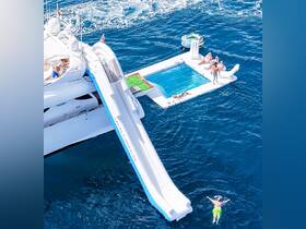 A lively scene featuring a group enjoying a water slide and pool on a luxury yacht, perfect for summer fun and unforgettable boating experiences.