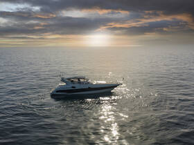 A stunning aerial view of a sleek yacht cruising through calm waters at sunset, showcasing the beauty of maritime adventures.