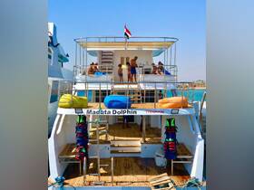 A lively scene aboard the 'Maduta Dolphin' with guests enjoying the sun and preparing for water activities — perfect for family adventures and group outings.
