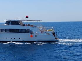 A sleek yacht cruising through clear blue waters, showcasing its elegant design and perfect for luxurious outings on the sea.