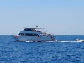 A sleek yacht cruises through clear blue waters, showcasing its elegant design and perfect for luxury outings on the sea.