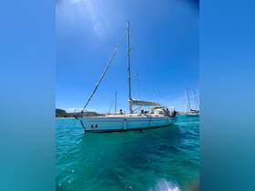 A beautiful sailboat glides through crystal-clear waters, with guests enjoying the sun on deck — perfect for a day of sailing adventures.