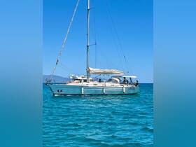 A beautiful sailboat glides through clear turquoise waters, with guests enjoying the sun on deck — perfect for a day of relaxation and adventure on the water.