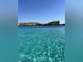 A stunning view of crystal-clear turquoise waters and rocky coastlines, perfect for showcasing the beauty of a boating adventure.