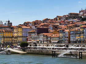 A scenic view of colorful buildings along a waterfront, showcasing the vibrant architecture of a coastal town.