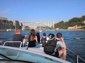 A group of friends enjoys a scenic boat ride, taking in the stunning views of the city and its iconic bridge — perfect for sightseeing and memorable outings on the water.