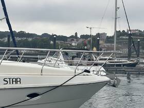 A boat named 'STAR' is docked with people visible onboard, showcasing a lively marina atmosphere.