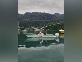 A sleek boat named 'Sea Mate' is anchored in calm waters, showcasing its design against a backdrop of lush mountains — perfect for exploring coastal destinations.