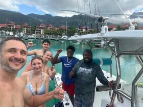 A cheerful group poses for a selfie aboard a boat at the marina, showcasing their excitement for a day on the water.