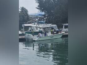 A lively group prepares for a fishing adventure aboard a boat at the dock, showcasing the excitement of family outings on the water.