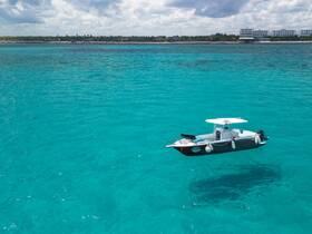A stunning aerial view of a boat floating in crystal-clear turquoise waters, showcasing the beauty of marine adventures.
