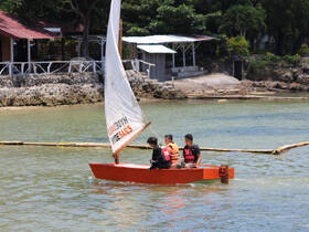 A group of children enjoys a sailing adventure on a small boat, showcasing the joy of outdoor activities and water sports.