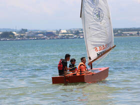 A group of friends enjoys a sailing adventure on a small boat, showcasing the joy of water activities and teamwork.
