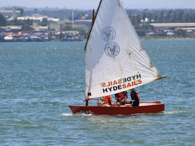A group of individuals enjoys a sailing experience on a small boat, showcasing the joy of on-water activities and adventure.