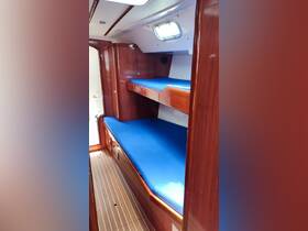Interior view of a boat cabin featuring two comfortable sleeping areas with blue cushions, ideal for relaxing during your nautical adventures.