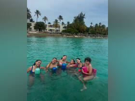 A joyful group of friends enjoys a fun day swimming in crystal-clear waters, perfect for beach celebrations and memorable outings.