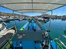 View of the helm area inside a colorful boat, showcasing the controls and seating, perfect for navigating the serene marina.