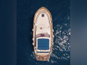 Aerial view of a luxurious yacht cruising through deep blue waters, showcasing its elegant design and spacious deck.