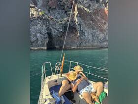 A couple relaxes on the deck of a boat, enjoying the sun and ocean views — a perfect moment for unwinding on the water.