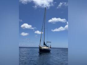 A stunning sailboat named 'Laser' glides through calm waters under a bright blue sky, showcasing the beauty of sailing adventures.