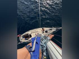An adventurous perspective from above a sailboat, showcasing the thrill of sailing on the open ocean with friends enjoying the experience.