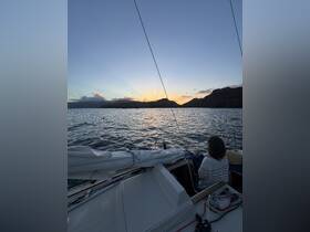 A serene sunset view from a boat with a guest enjoying the tranquil waters — perfect for capturing the beauty of nature during a relaxing cruise.