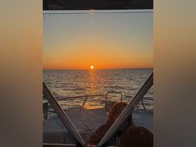 A stunning sunset view from aboard a boat, capturing the serene moment as the sun dips below the horizon — perfect for romantic evenings or peaceful cruises.