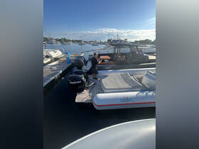 A man stands on the dock next to a motorboat, preparing for a day on the water at a marina. The scene captures the essence of boating life with multiple vessels in the background.