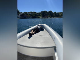 A person relaxes on the bow of a boat under the sun, enjoying a peaceful day on the water — perfect for unwinding and soaking up the scenery.