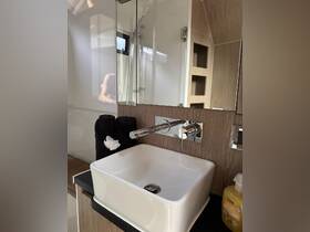 A modern bathroom sink setup inside a boat, featuring sleek design elements and neatly arranged towels, perfect for onboard comfort.