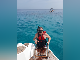 A snorkeler prepares to dive into the crystal-clear waters, showcasing the excitement of underwater exploration from a boat.