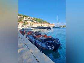 A sleek speedboat docked at a picturesque harbor, surrounded by charming coastal buildings and clear blue waters, perfect for exploring the scenic coastline.
