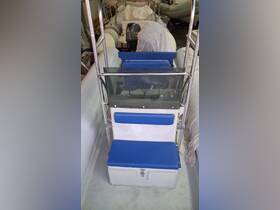 Interior view of a boat's helm seating area, featuring blue cushions and a storage compartment, ideal for comfortable navigation.