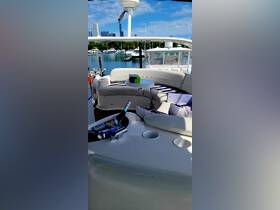 A stylish interior view of a boat's lounge area featuring comfortable seating and a small table, perfect for relaxing while enjoying the waterfront scenery.