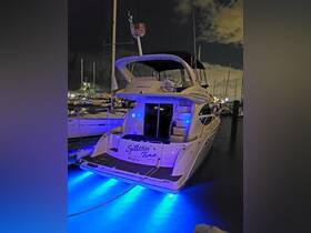 A beautifully lit yacht named 'Splittin' Time' docked at night, showcasing its elegant design and vibrant underwater lights — perfect for evening cruises.