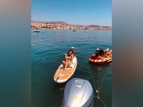 A group of friends enjoys a sunny day paddleboarding and relaxing on the water, showcasing the perfect summer getaway.