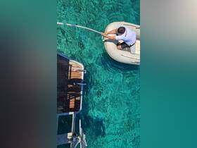 A person maneuvers a small boat in crystal-clear waters, showcasing the excitement of on-water activities and the beauty of the marine environment.