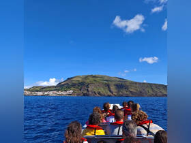 A group of guests enjoys a scenic boat ride with stunning views of the island and ocean, perfect for exploring the beautiful coastline.