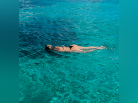 A snorkeler glides through crystal-clear waters, enjoying the vibrant marine life below — a perfect scene for underwater adventures.
