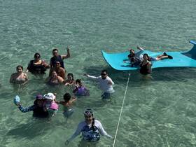 A lively group enjoys a fun day in the shallow waters, showcasing family bonding and water activities — perfect for memorable outings and celebrations.