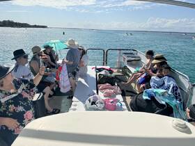 A lively group enjoys a sunny day on a boat, showcasing family fun and relaxation on the water.