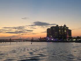 A picturesque sunset view over a bustling harbor, with silhouettes of people enjoying the waterfront atmosphere — a perfect backdrop for evening outings.